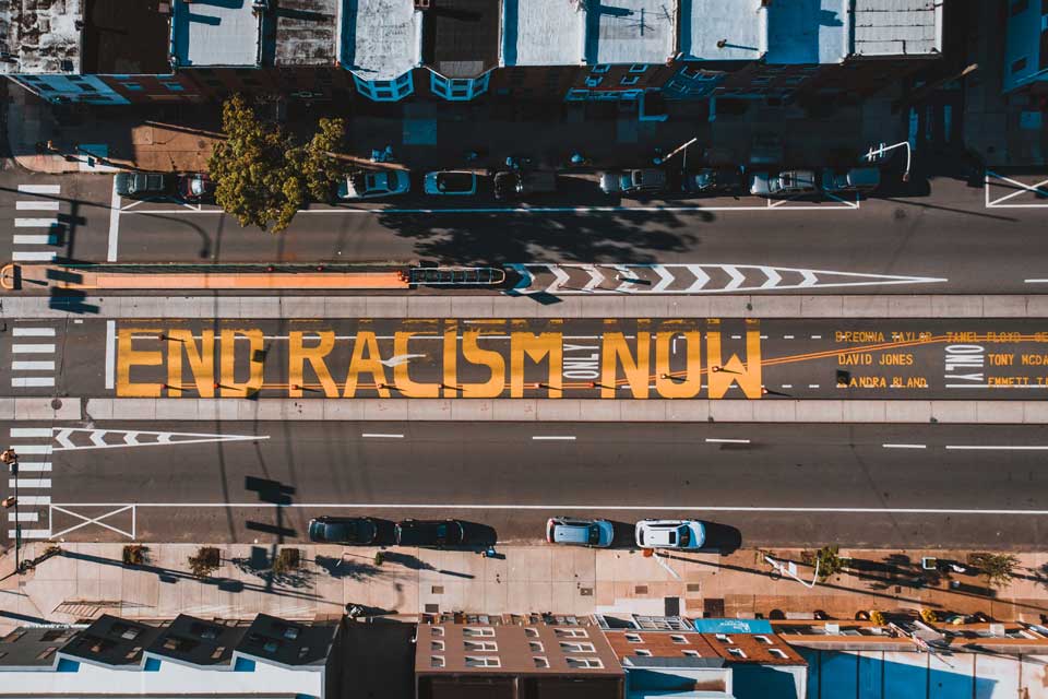 Overhead view of a street that the words End Racism Now are painted.